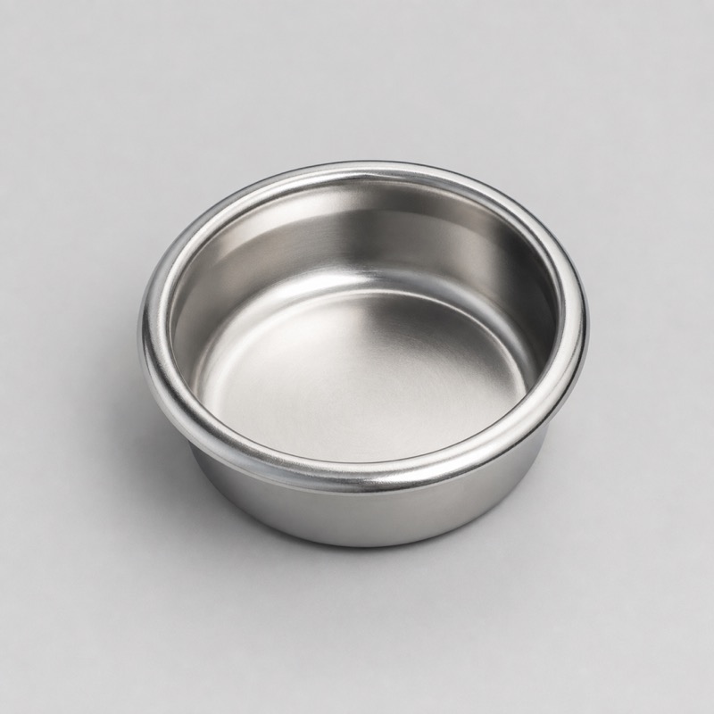 Stainless steel filter basket with a solid floor and no holes, seen from above