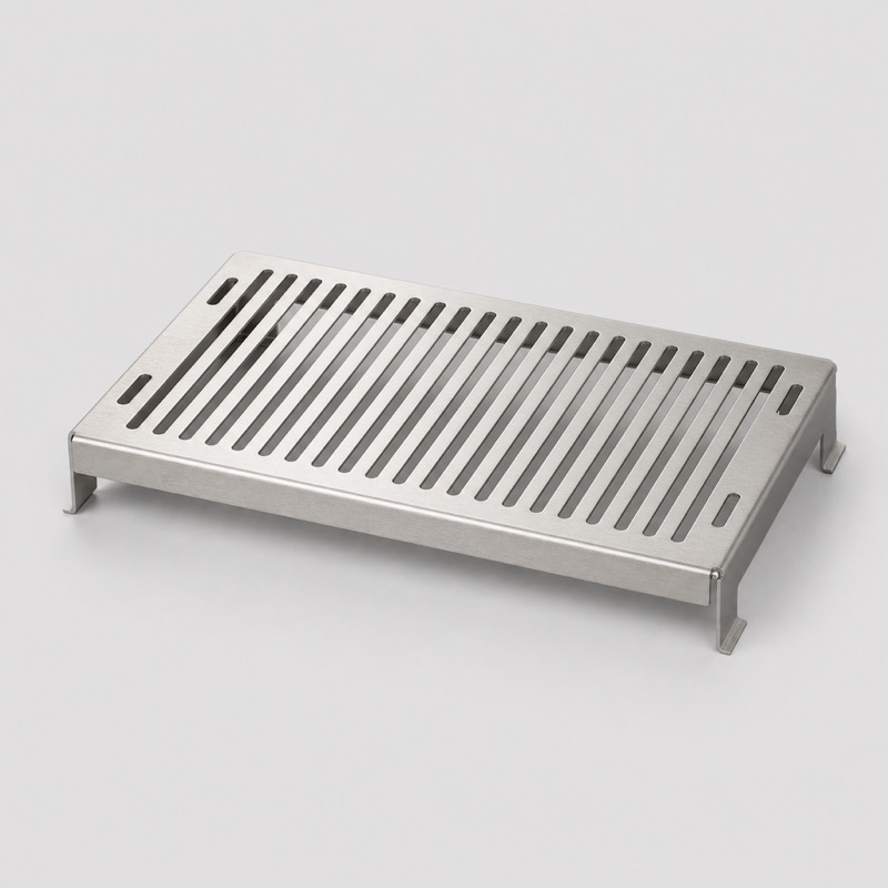 Rectangular stainless steel drip tray grid with punched slots, standing on folded feet