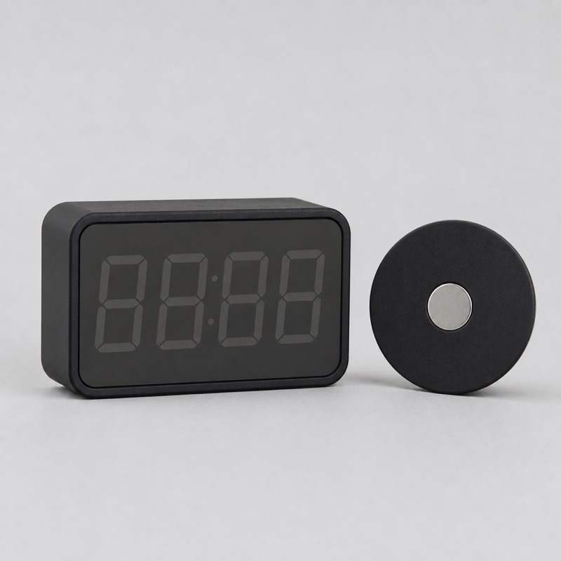 Small black digital shot timer standing upright, with a large four-digit display