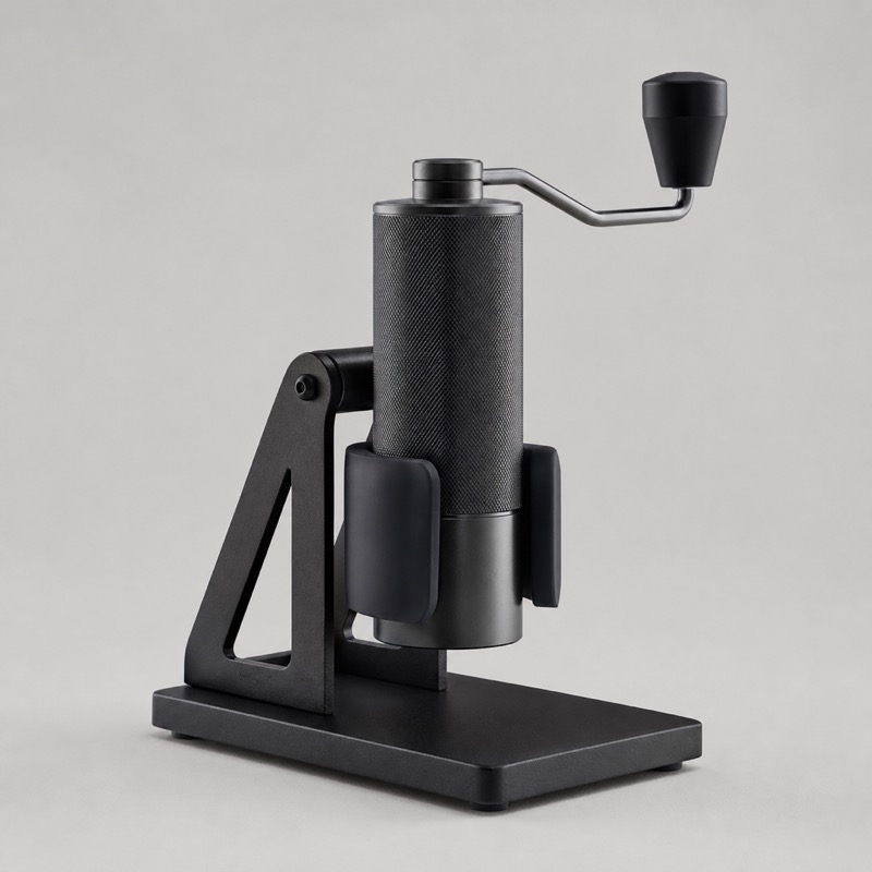Black steel stand cradling a cylindrical hand grinder upright on a counter