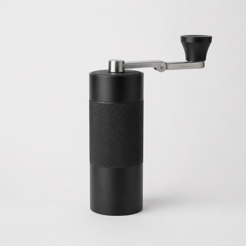 Small black cylindrical hand grinder with a folding steel crank on top