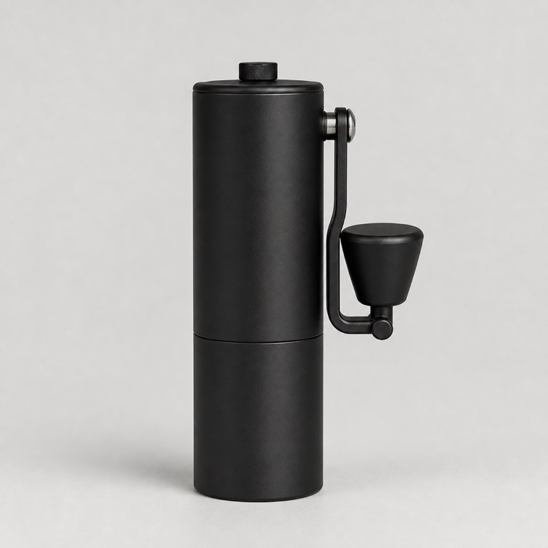 Black cylindrical hand coffee grinder with a folding crank handle
