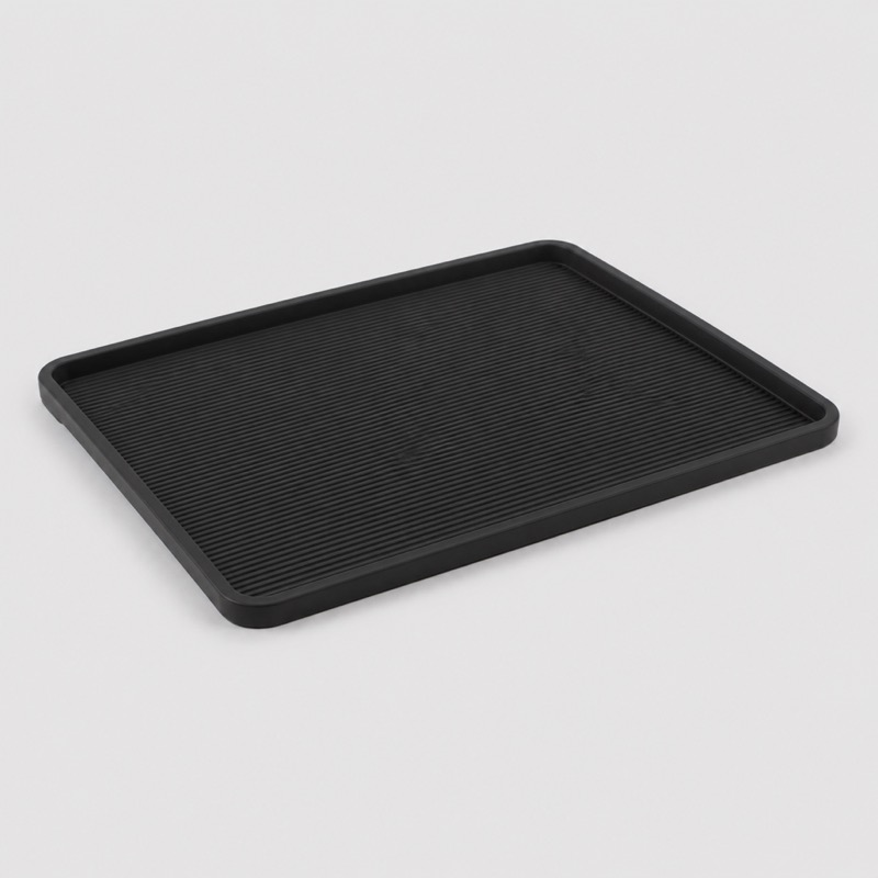 Flat black rectangular mat with a raised lip and a ribbed surface